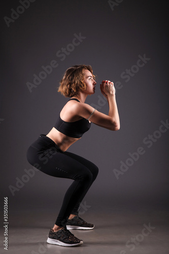 Young girl doing yoga on a black background