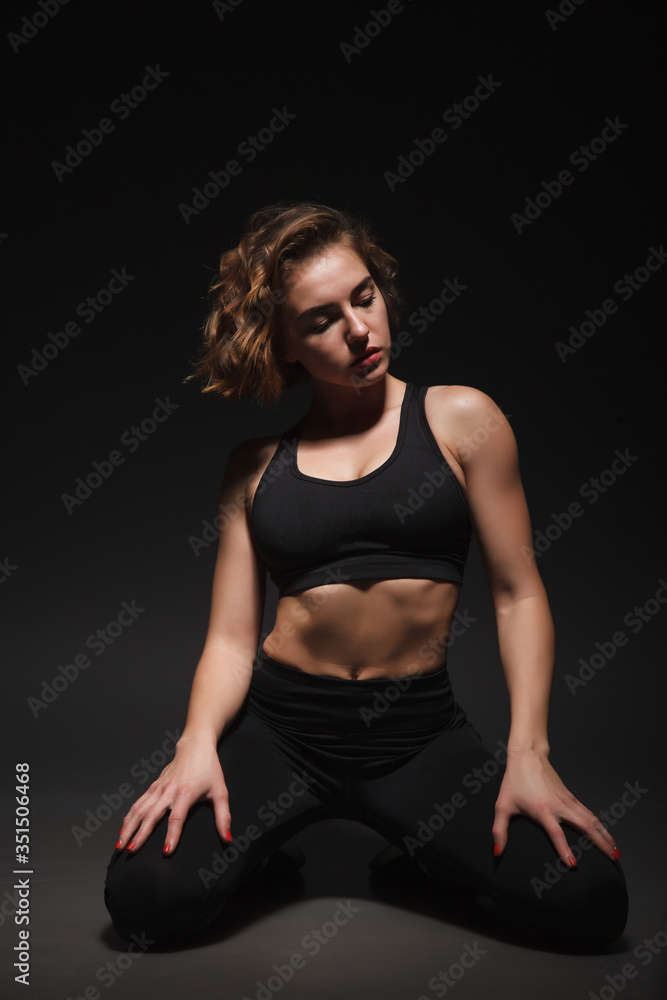 Young girl doing yoga on a black background Young girl doing yoga on a black background