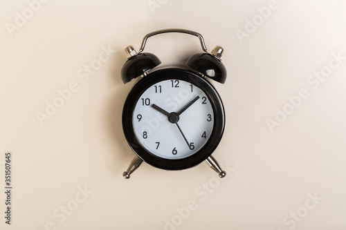 black vintage alarm clock on a colored background, top view. concept of time, daily routine
