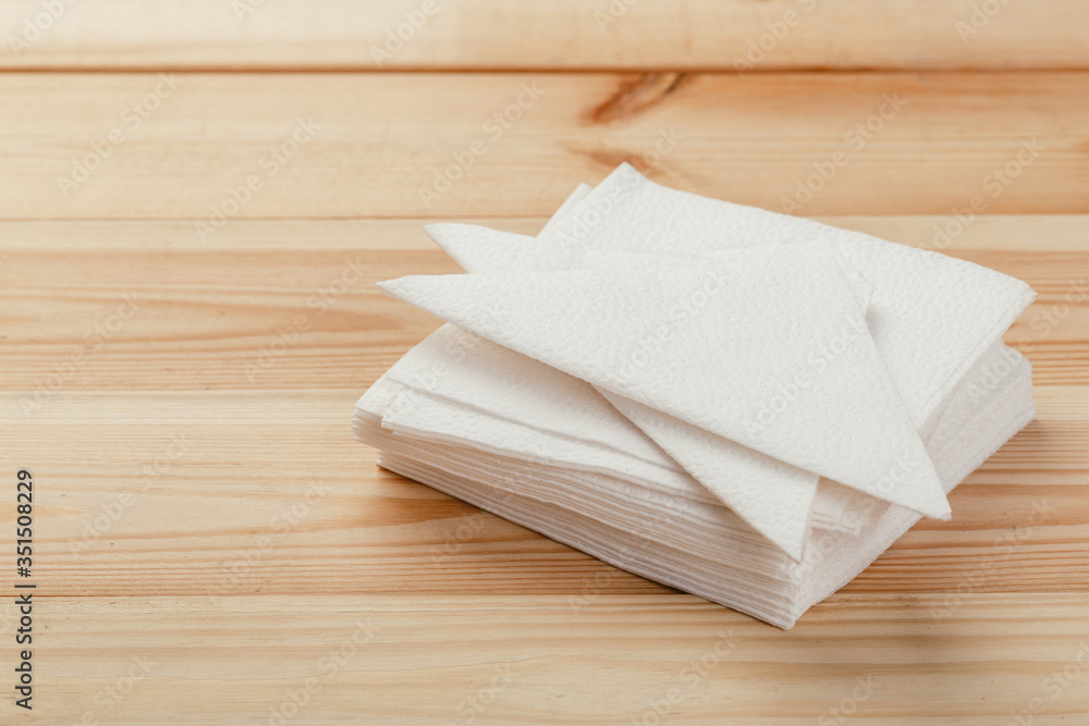 white paper napkin or tissue on the wooden table background. white paper napkin or tissue on the wooden table background.