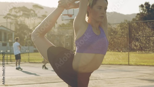 Young Fit Woman Does King Dancer Pose Yoga Stretch on Sunny Morning photo