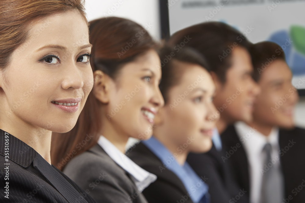 Side view shot of business people sitting together Side view shot of business people sitting together