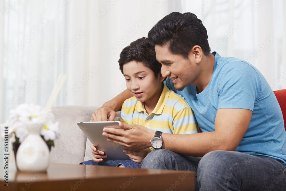 Father and son using a digital tablet together
