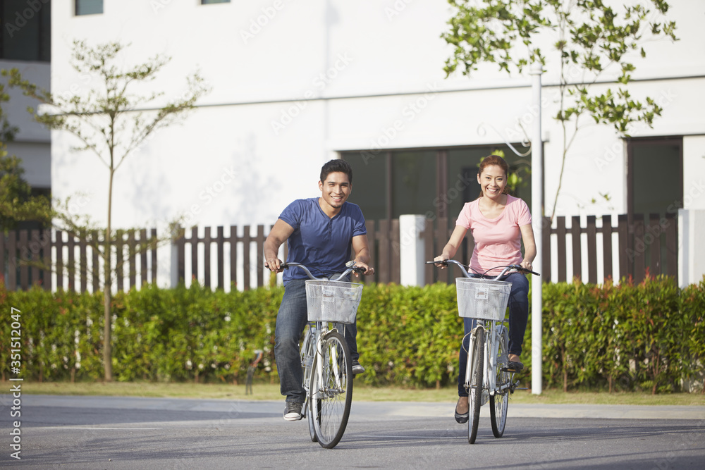 Man and woman riding a bicycle together