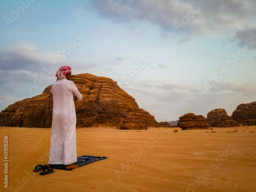 Devout Muslim performing evening prayer in the desert of Wadi-Rum, Jordan. photo