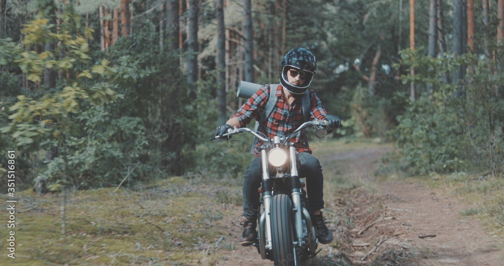 Young rider driving motorcycle on forest road Young rider driving motorcycle on forest road