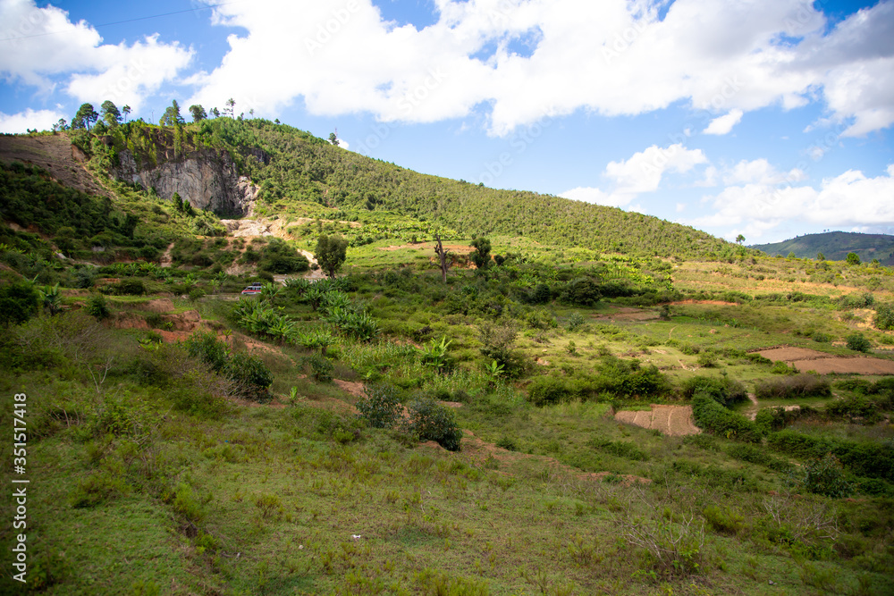 Naklejka premium Mountains covered with plants and a blue sky with small clouds