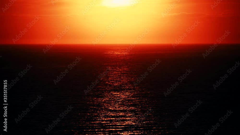 Red sunset, sunlight reflecting in sea water surface. Evening seascape in burning orange color Red sunset, sunlight reflecting in sea water surface. Evening seascape in burning orange color