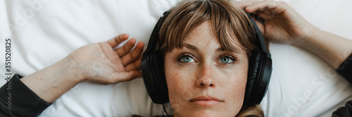 Woman listening to music at home during coronavirus pandemic photo