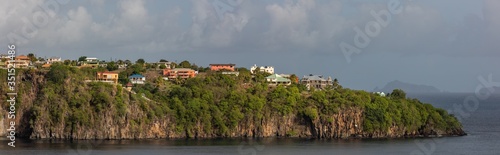 Beautiful panoramic aerial view of a cliff with some buildings and houses on it on St. Vincent island