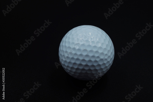 White golf ball on black background with copy space