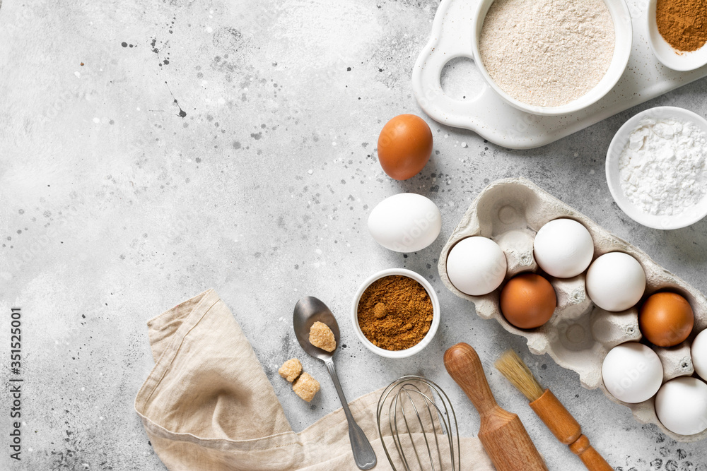 Ingredients for baking on a culinary background. Eggs, flour, cinnamon, sugar, soda on the kitchen table. Concept of preparation for baking. Top view with space for text Ingredients for baking on a culinary background. Eggs, flour, cinnamon, sugar, soda on the kitchen table. Concept of preparation for baking. Top view with space for text