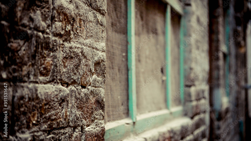 Brow brick wall with wooden green frame of window Brow brick wall with wooden green frame of window