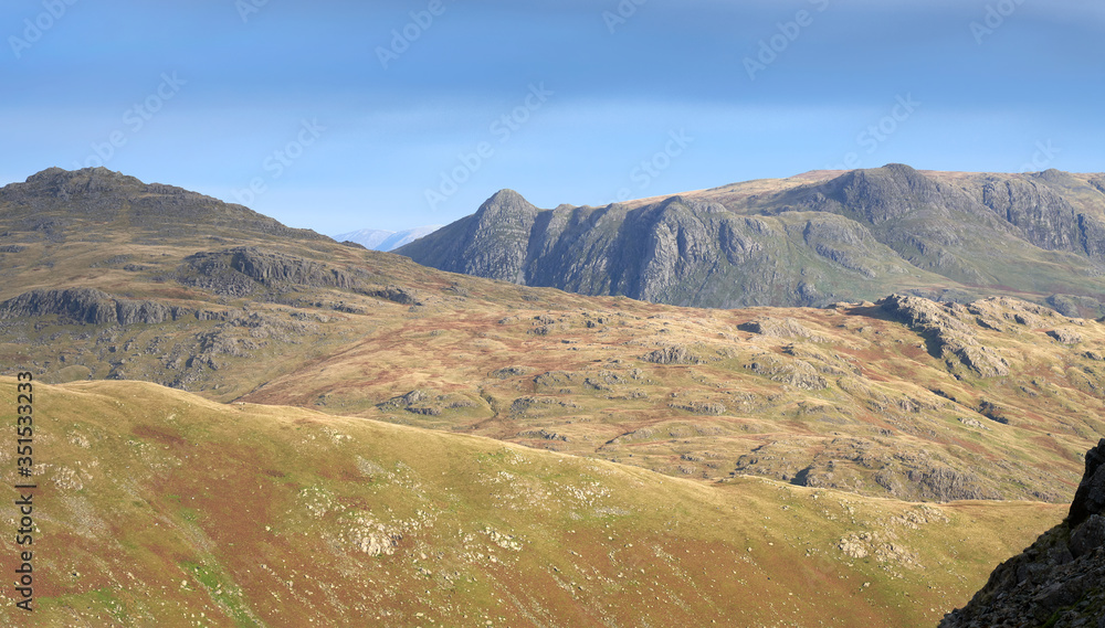 Views of Langdale Pikes and Pavey Ark from Prison Band below Swirl How on a sunny day in the Lake District. Views of Langdale Pikes and Pavey Ark from Prison Band below Swirl How on a sunny day in the Lake District.