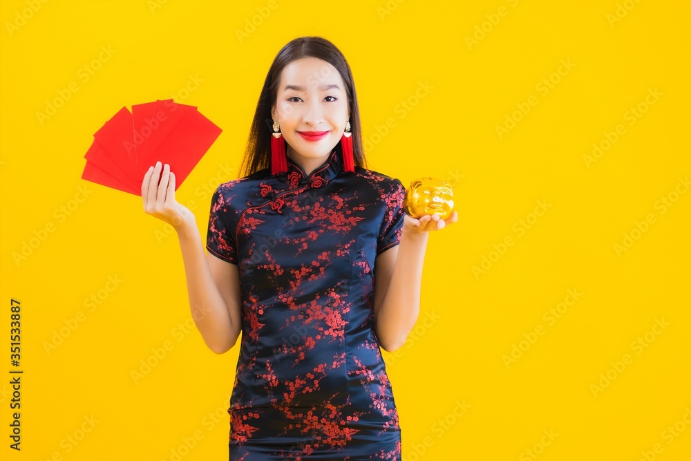 Portrait beautiful young asian woman wear chinese dress show gold piggy bank Portrait beautiful young asian woman wear chinese dress show gold piggy bank