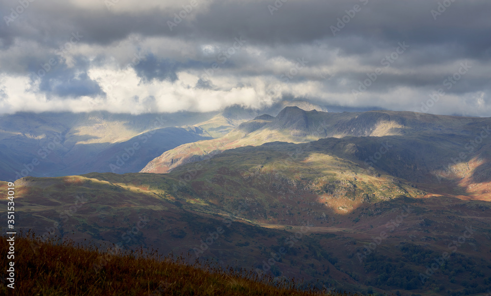 The summits of Crinckle Crags and Bow Fell in the cloud and Harison Stickle to the right and Silver How in the foreground in the Lake District.