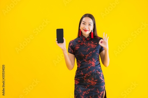 Obraz na plátně Portrait beautiful young asian woman wear chinese dress use smart mobile phone