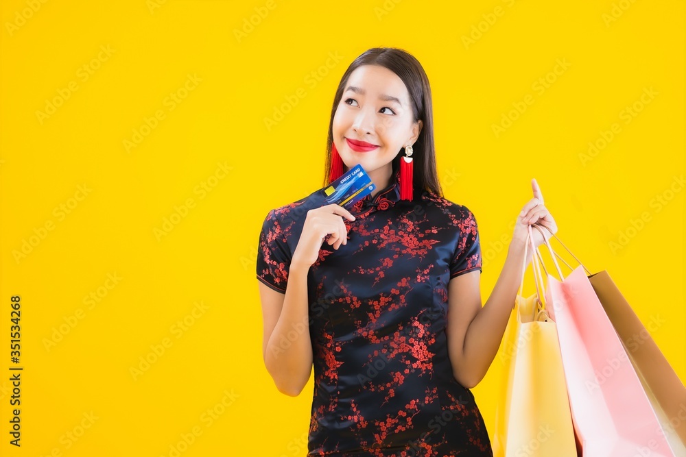 Portrait beautiful young asian woman wear chinese dress with shopping bag Portrait beautiful young asian woman wear chinese dress with shopping bag