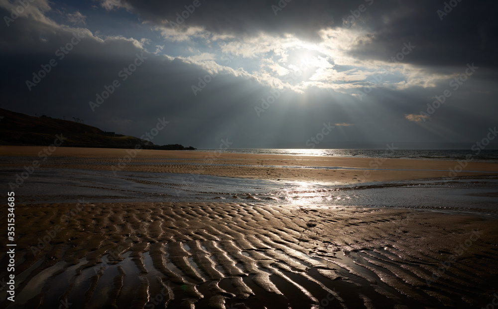 Rays of autumn sunlight breaking through the cloud over the rippled sands of Big Sand beach near Gairloch in the Scottish Highlands, Scotland, UK.