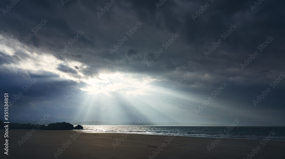 Rays of autumn sunlight breaking through the cloud at the beach of Big Sand near Gairloch with sun rays lighting the sea in the Scottish Highlands, Scotland, UK. Rays of autumn sunlight breaking through the cloud at the beach of Big Sand near Gairloch with sun rays lighting the sea in the Scottish Highlands, Scotland, UK.