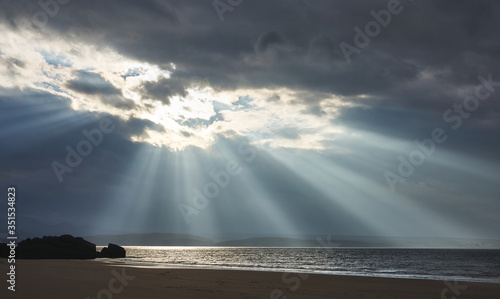 Rays of autumn sunlight breaking through the cloud at the beach of Big Sand near Gairloch in the Scottish Highlands  Scotland  UK.