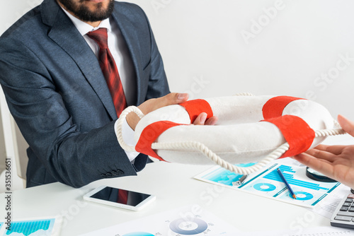 Business persons holding small lifebuoy together photo