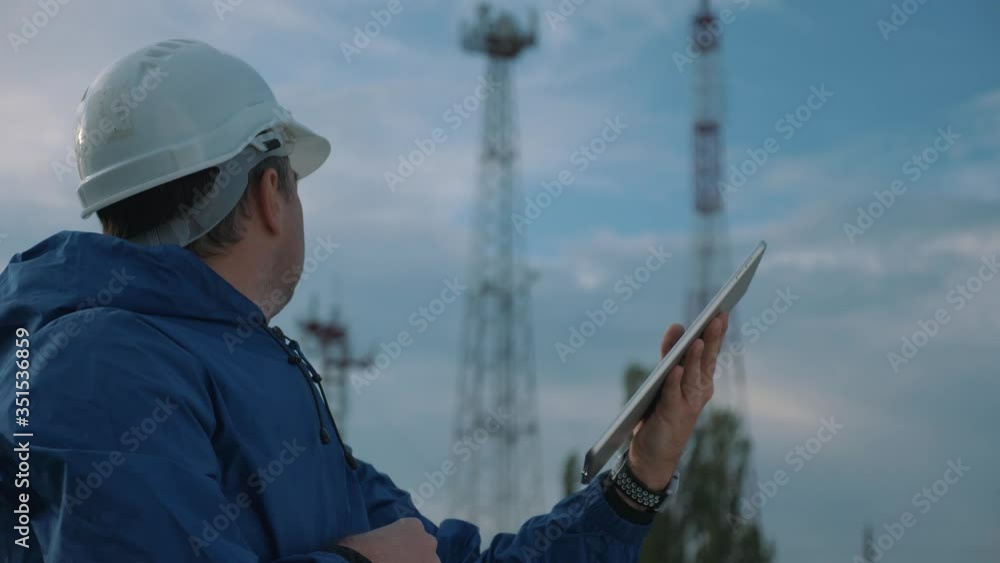 A telecommunications engineer working on a digital tablet records data for maintenance of the telecommunications network. Design, repair and installation of satellite and telecommunications networks. A telecommunications engineer working on a digital tablet records data for maintenance of the telecommunications network. Design, repair and installation of satellite and telecommunications networks.