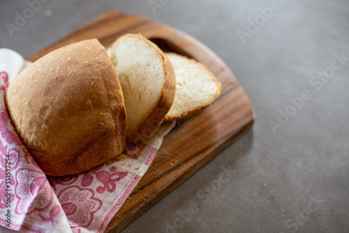 Wheat homemade bread on a wooden desk. Grey background. Horizontal.