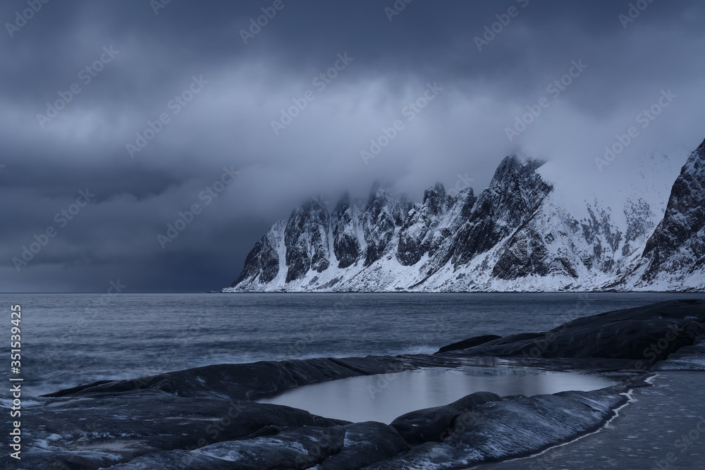 Rocky sea coast covered with snow, Senja Island, Norway