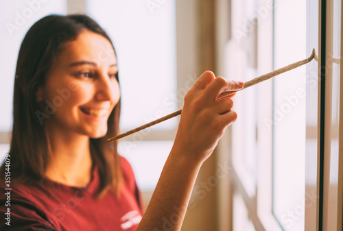 Φωτογραφία Woman painting her house with a brush
