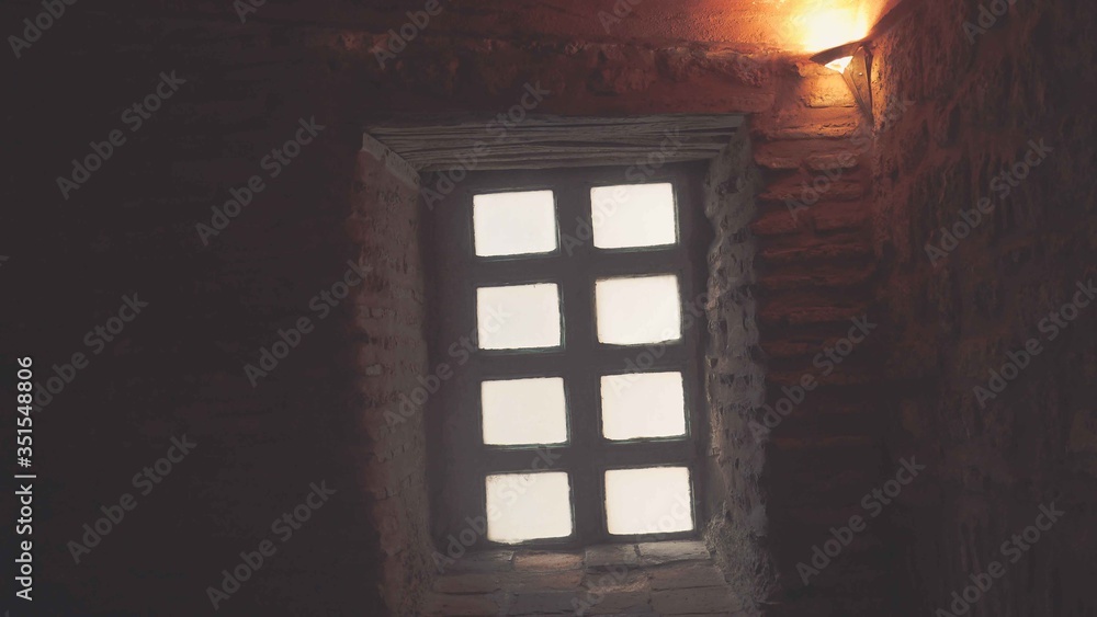 Wooden window with white wooden frame on brick wall
