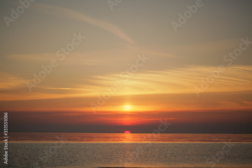 Dramatic sunset at sea. The sun set halfway over the horizon © DiedovStock
