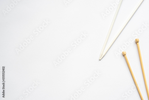 top view of knitting needles on white background