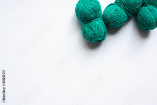 top view of green wool yarn on white background with copy space