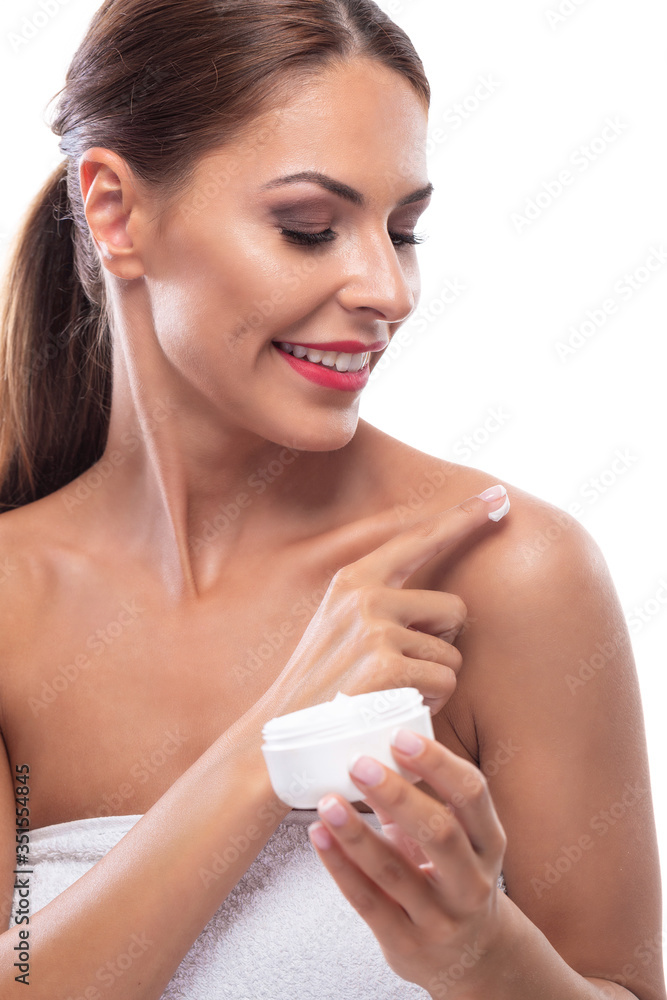 Lovely brunette young woman applying body cream on her shoulder Lovely brunette young woman applying body cream on her shoulder