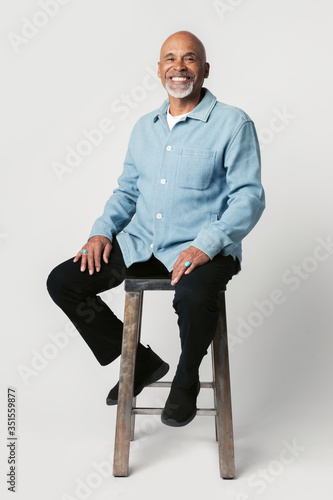 Happy retired man sitting on a stool