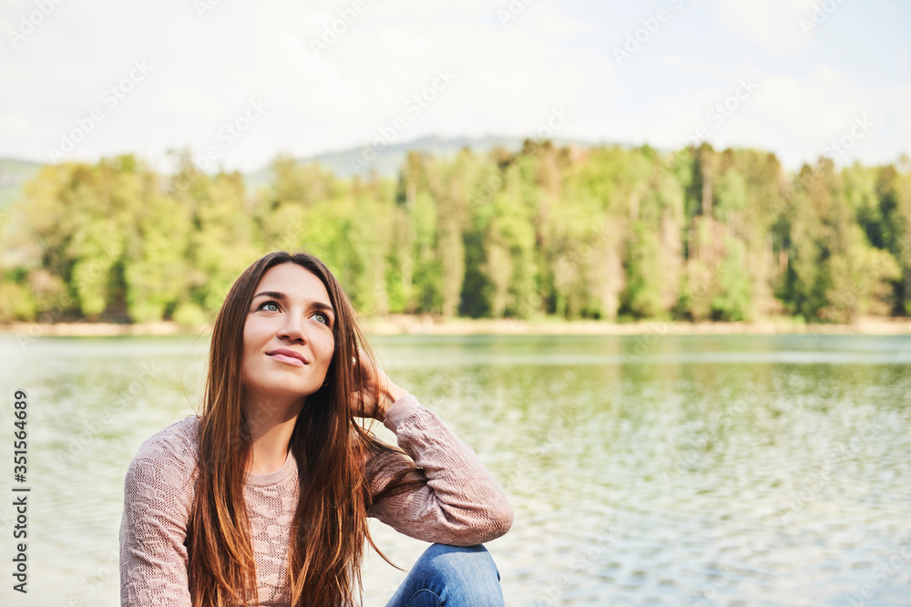 Outdoor portrait of young beautiful woman relaxing by river on a nice warm day Outdoor portrait of young beautiful woman relaxing by river on a nice warm day
