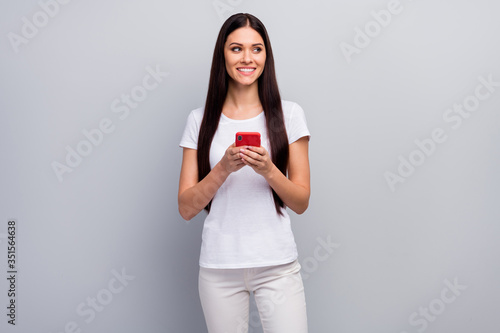 Portrait of her she nice attractive lovely pretty cute charming cheerful cheery straight-haired girl holding in hands using cell 5g app isolated over light gray pastel color background