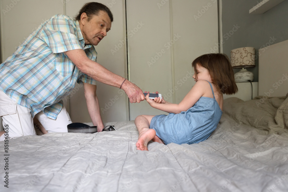 father takes away a smart phone from child girl, children’s digital addiction, the concept of children and gadgets father takes away a smart phone from child girl, children’s digital addiction, the concept of children and gadgets
