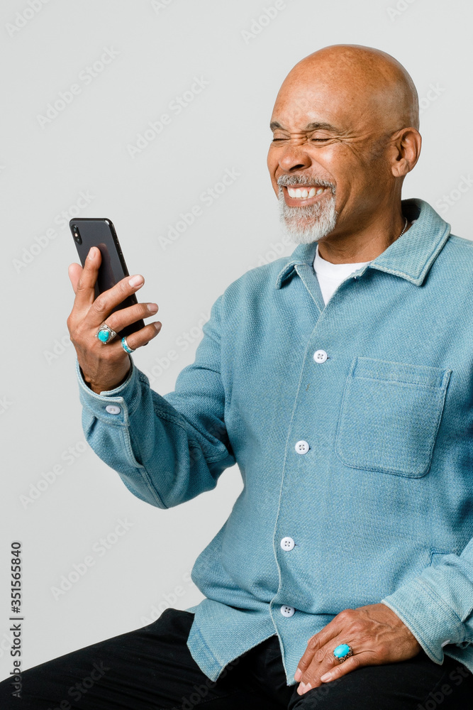 Happy retired man using a smartphone Happy retired man using a smartphone