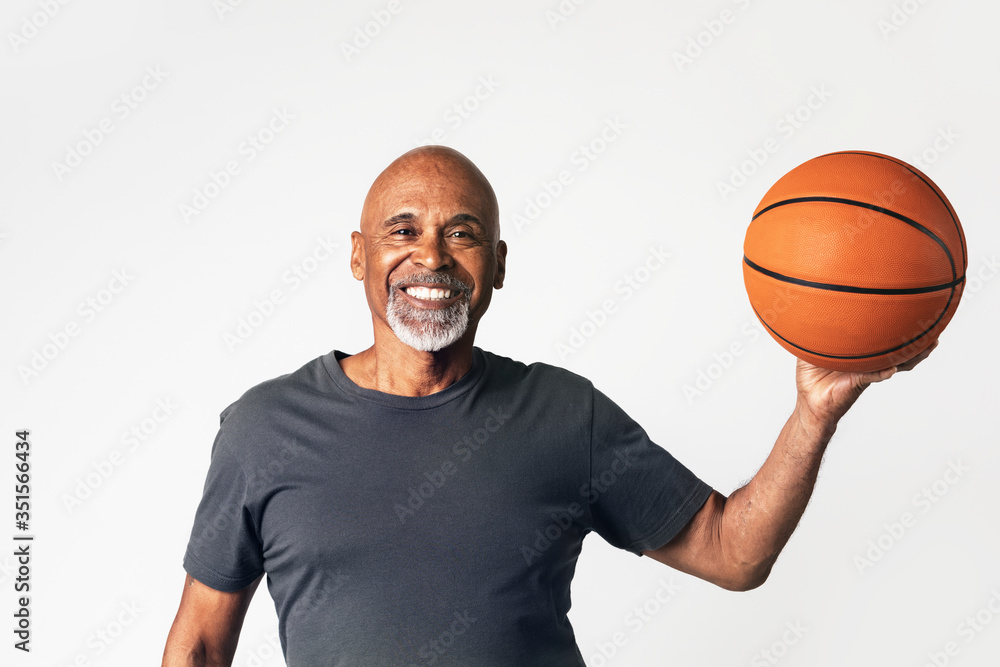 Senior coach holding a basketball - obrazy, fototapety, plakaty 
