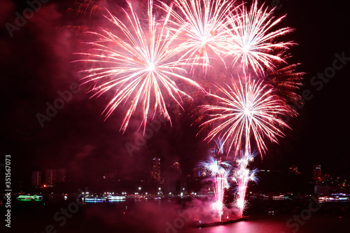 Fantastic red fireworks splashing in the night sky over the harbor