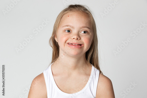 Cute girl with Down Syndrome in a white tank top portrait