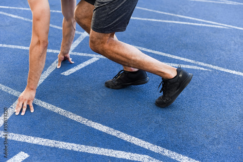 cropped view of runner in start position on running track at stadium