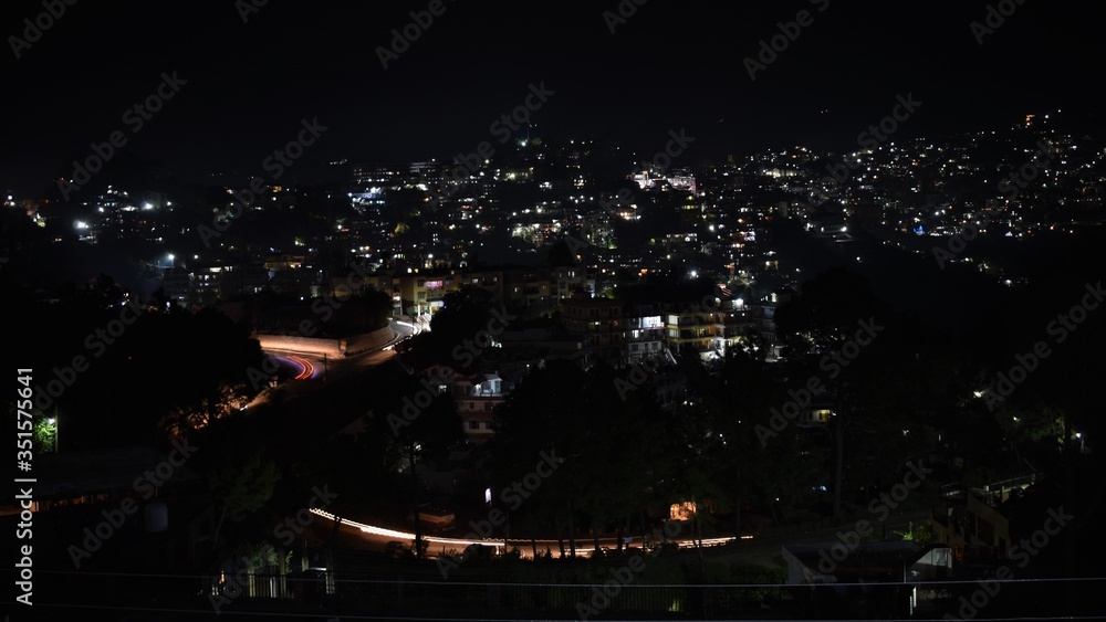 A long exposure shot of a hilly town in the night