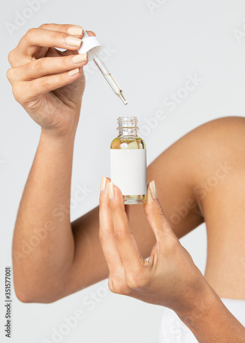 Woman using a dropper bottle mockup