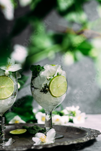 Cold cocktail with mint, lime and ice in a glass