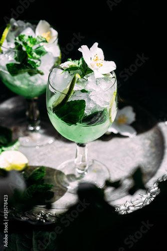 Cold cocktail with mint, lime and ice in a glass