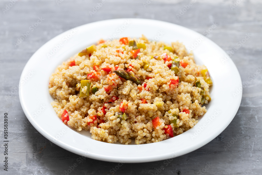 quinoa with vegetables on white plate on ceramic background quinoa with vegetables on white plate on ceramic background