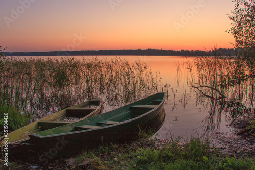 wooden boats near the shore at sunset